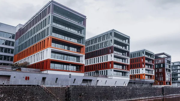 Modern waterfront residential buildings with colorful metal accents and glass windows