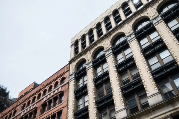 Historic brick and stone buildings with large arched windows and ornate architectural details
