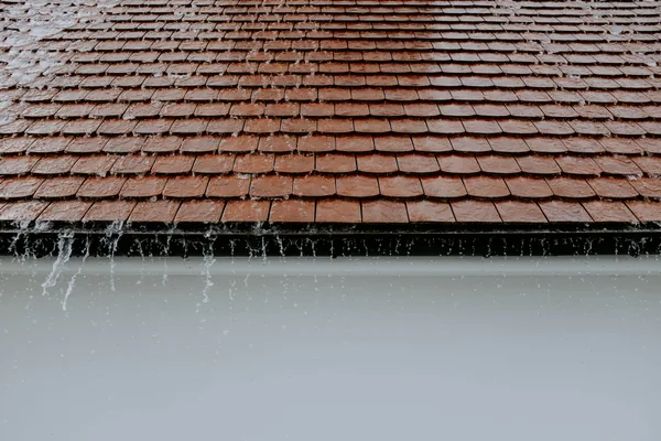 Frozen icicles hanging from roof gutter edge during winter weather