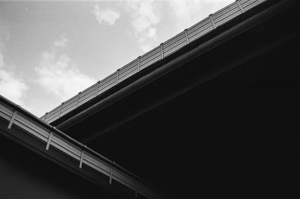 Underside view of concrete highway bridge with metal railings and support structure