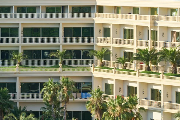 Multi-story residential building with numerous windows and ornate balconies