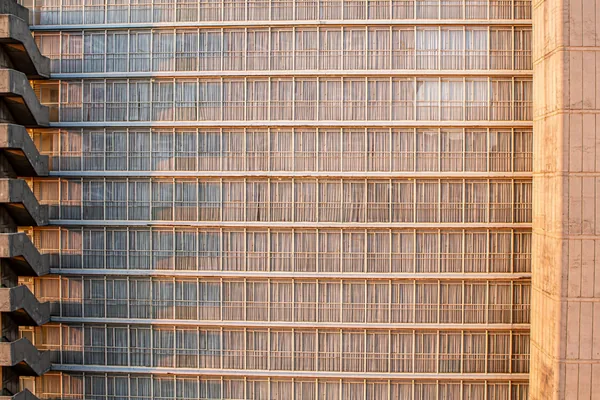Modern high-rise building facade with repetitive metal and glass window pattern
