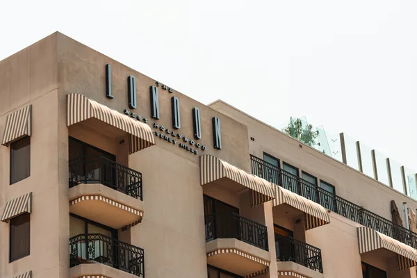 Multi-story residential building with balconies and exterior windows needing cleaning