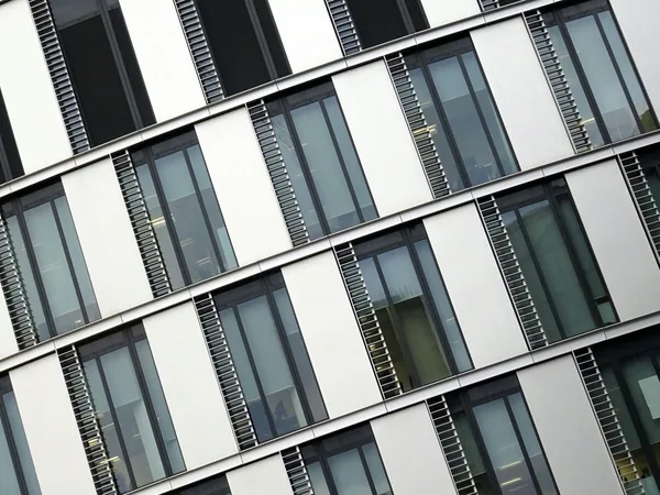 Modern building facade with alternating white panels and multi-pane windows