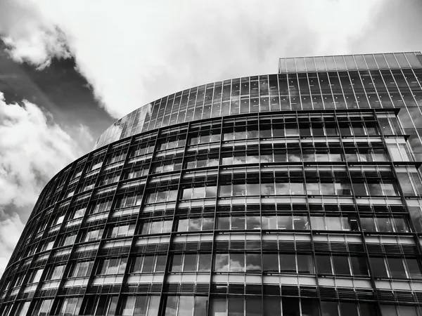 Modern curved glass building facade with geometric window grid pattern