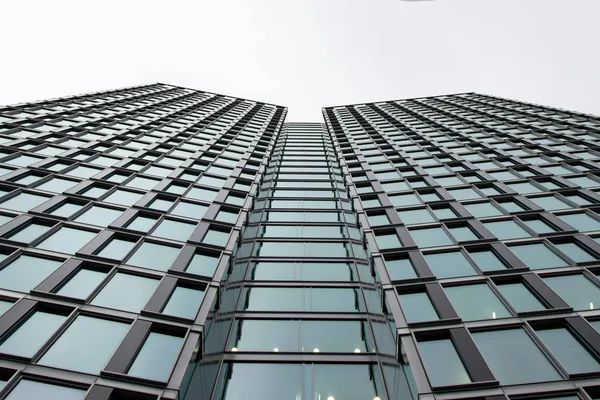 Modern skyscraper facade with grid pattern of windows and dark frames