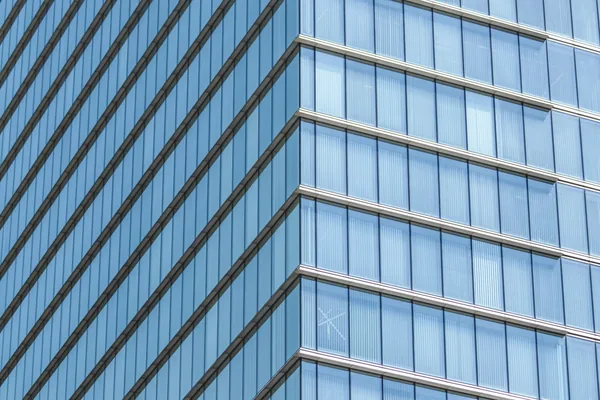 Modern glass skyscraper exterior with reflective windows and metal framework