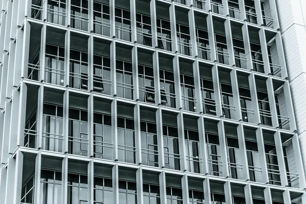 Modern commercial building facade with rows of large windows and balconies