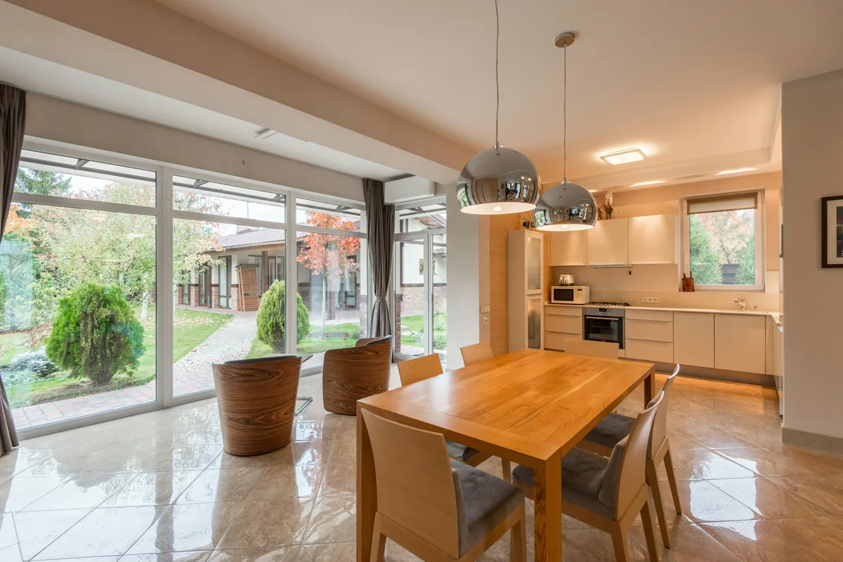 Modern kitchen and dining room with large clean windows overlooking garden